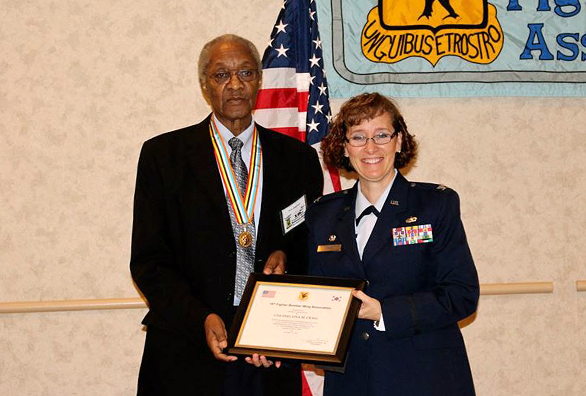 Tom Chapman, 18th Fighter Bomb Wing Association president, thanks Col. Lisa Craig, 433rd Mission Support Group commander, for speaking at the 18th FBW reunion dinner Oct. 24 at the Double Tree Hotel San Antonio, Texas. Twenty-five Korean War veterans were honored with the Republic of Korea Ambassador for Peace Medal, a commemorative medal produced by the Korean Government as an expression of gratitude and honor to America's Korean War veterans. (Photo by Susan Kee) (released)