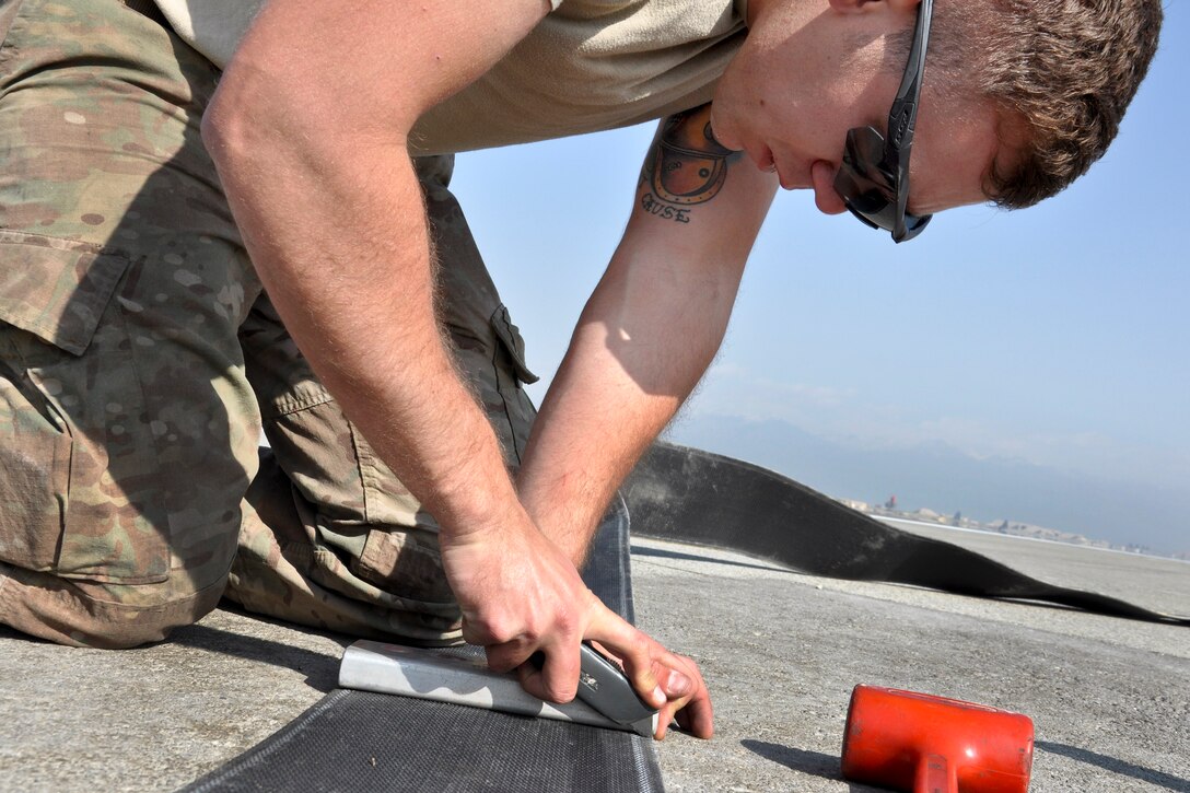 U.S. Air Force Senior Airman Yves Meillarec cuts a piece of cable for the aircraft arresting cable system on Bagram Airfield, Afghanistan, Oct. 22, 2015. Meillarec is assigned to the 455th Expeditionary Civil Engineer Squadron. U.S. Air Force photo by Tech. Sgt. Nicholas Rau