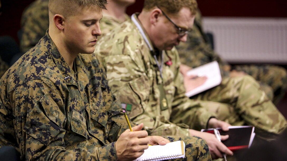 U.S. Marine 1st Lt. Joseph Ryan, a watch officer with 2nd Intelligence Battalion and British soldiers take notes before beginning Exercise Phoenix Odyssey II in Edinburgh, U.K., Oct. 25, 2015. The two-week exercise allows the two forces to enhance intelligence capabilities and build upon military skills. 