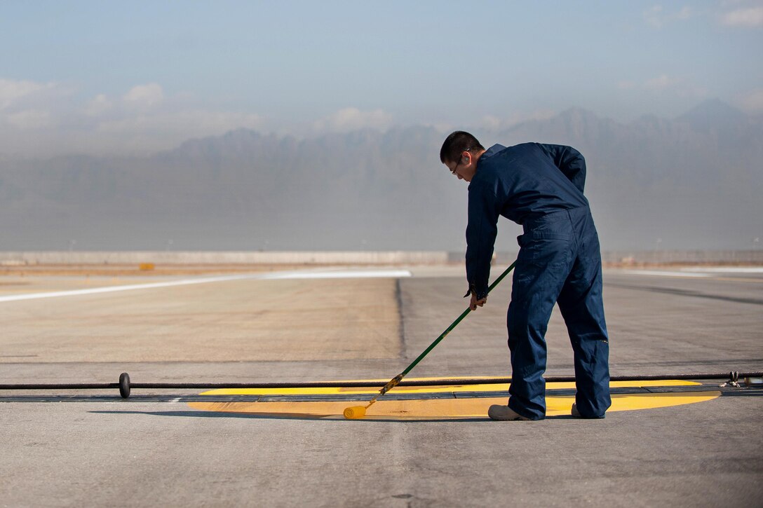 U.S. Air Force Airman 1st Class Elliot Oh paints runway markings on Bagram Airfield, Afghanistan, Oct. 22, 2015. Oh is assigned to the 455th Expeditionary Civil Engineer Squadron. U.S. Air Force photo by Tech. Sgt. Joseph Swafford