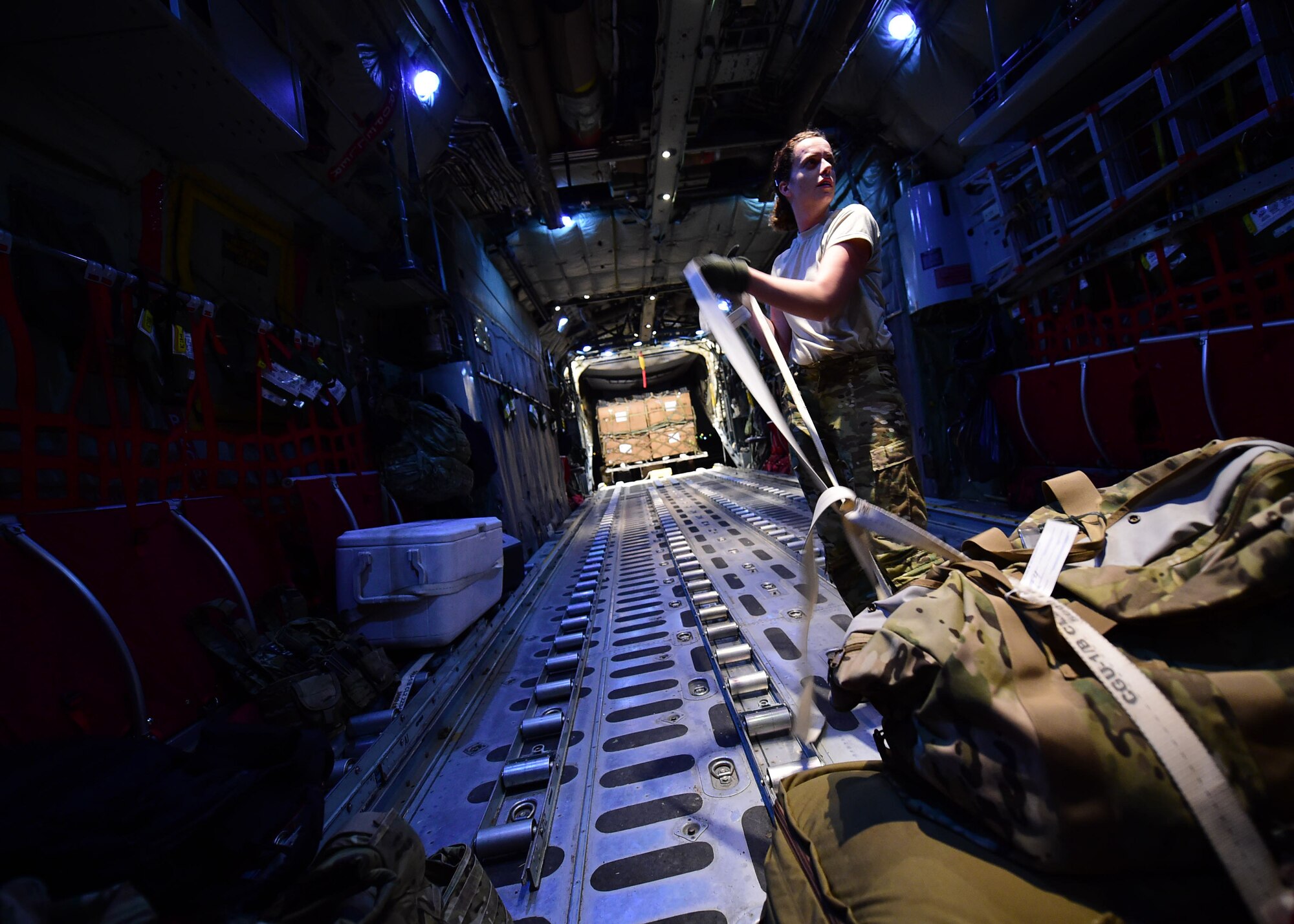 Senior Airman Erin Stewart, 737th Expeditionary Airlift Squadron loadmaster, secures cargo onboard a C-130H Hercules at an undisclosed location in Southwest Asia, Oct. 27, 2015. The 737th EAS conducts airlift, airdrop and reconnaissance missions in support of Operation INHERENT RESOLVE. (U.S. Air Force photo by Staff Sgt. Jerilyn Quintanilla)