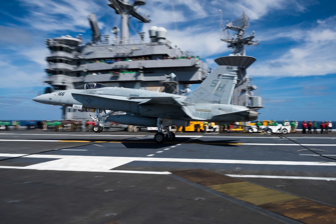 An F/A-18C Hornet assigned to the Sharpshooters of Marine Fighter Attack Training Squadron 101 catches an arresting gear cable as it lands aboard the flight deck of the USS John C. Stennis in the Pacific Ocean, Oct. 23, 2015. U.S. Navy photo by Petty Officer 3rd Class Kenneth Rodriguez Santiago