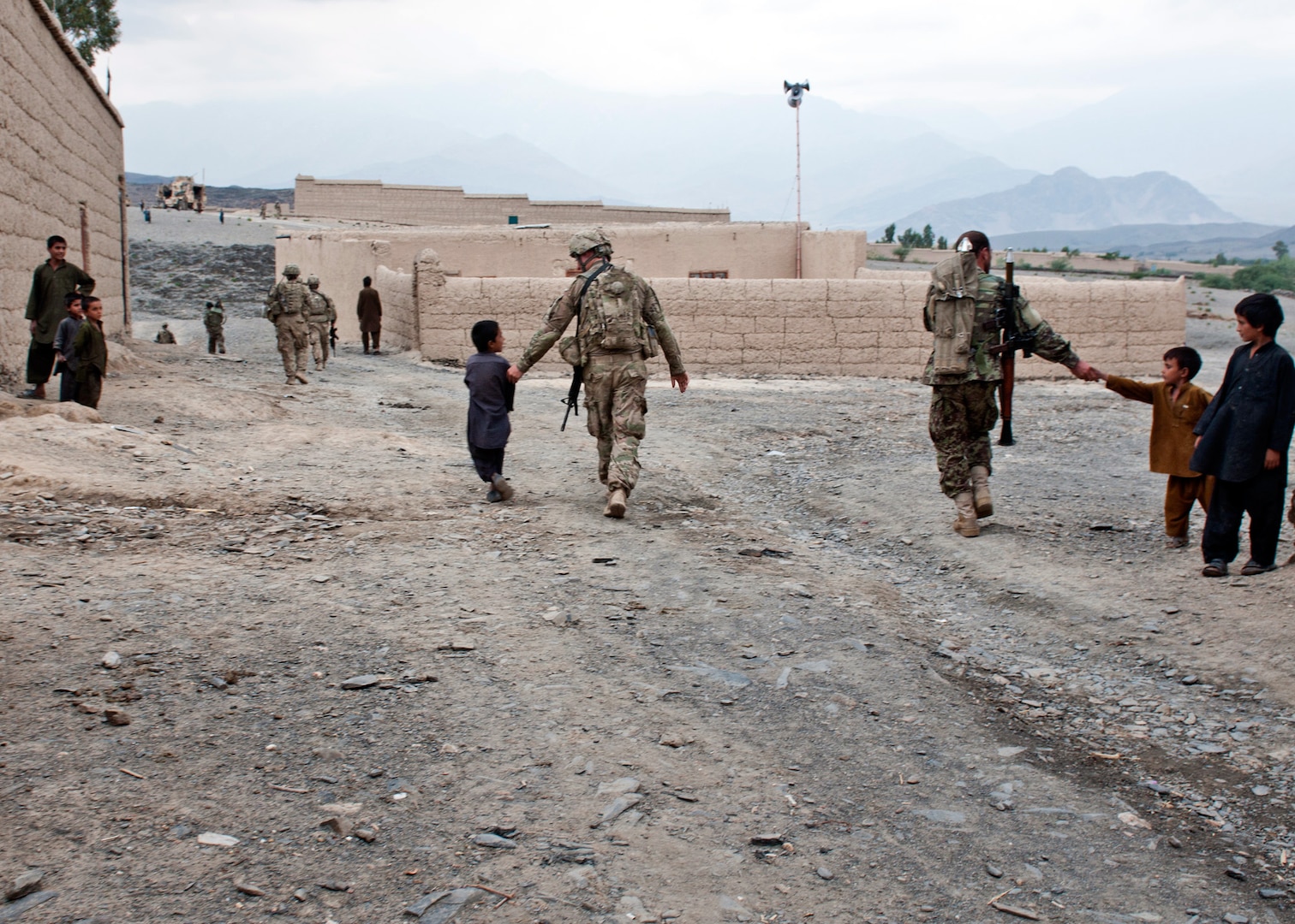 Children in the Sangar Valley reach out to soldiers from 1st Brigade 201st Corps, Afghan National Army and Soldiers form 45th Infantry Brigade Combat Team as they walk back to the mouth of the valley on Oct. 2, 2011. The ANA and 45th IBCT worked together to clear the valley of insurgent activity and to show the local villagers that they are committed to fighting the insurgency wherever it may be.