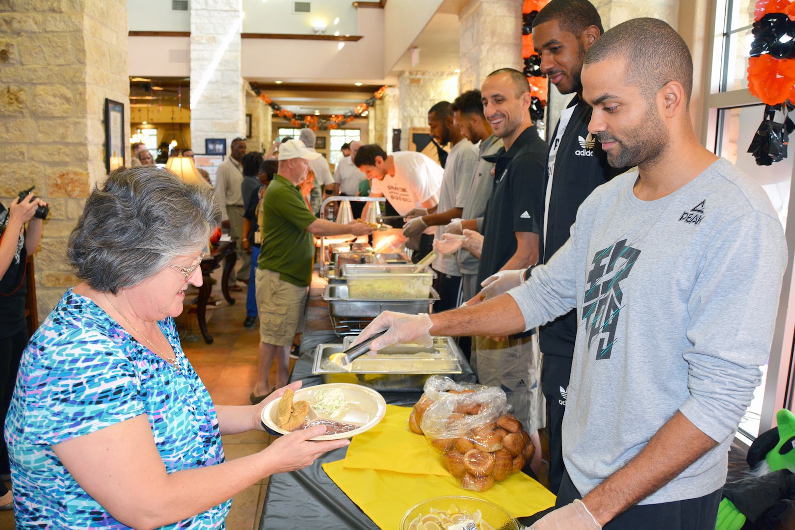 Spurs player Tony Parker (far right) and his teammates served lunch at the Warrior and Family Support Center Oct. 21. The team visited with warriors, family members and staff and signed autographs before heading over to the Center for the Intrepid to visit with patients and play wheelchair basketball.