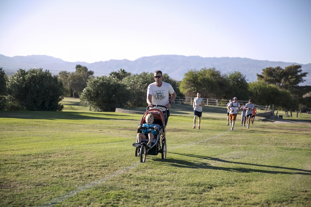 Capt. Sean Tracy, intelligence officer, 7th Marine Regiment, pushes his son, Presley, 3, in a stroller as part of the Substance Abuse Prevention Program’s second annual Red Ribbon Week 5k Race during the second annual Red Ribbon Week 5k at the Desert Winds Golf Course, Oct. 23, 2015. (Official Marine Corps photo by Lance Cpl. Thomas Mudd/Released)