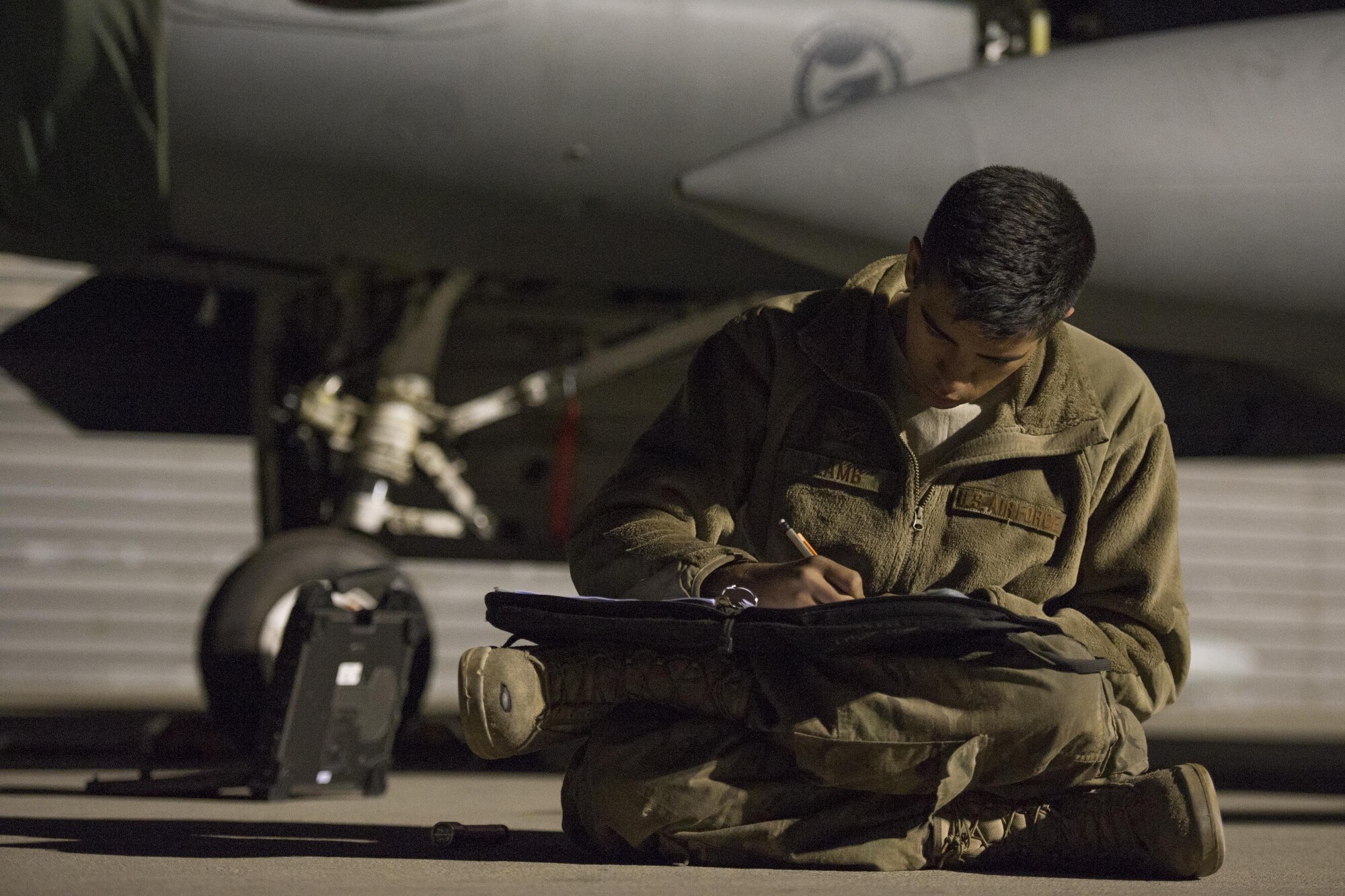 Airman 1st Class Christian Lamb, 455th Expeditionary Aircraft Maintenance Squadron assistant dedicated crew chief, deployed from Aviano Air Base, Italy, signs maintenance paperwork at Bagram Airfield, Afghanistan, Oct. 28, 2015. The 421st Fighter Squadron from Hill Air Force Base will relieve the 555th Expeditionary Fighter Squadron from Aviano this month. (U.S. Air Force photo by Tech. Sgt. Robert Cloys/Released)