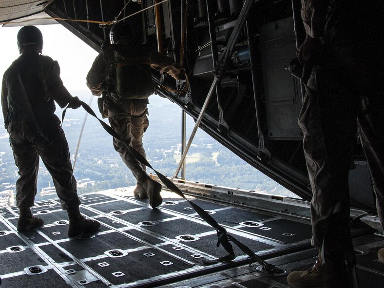 Marines from the 4th Recon Battalion Bravo Company rush out of the back of a U.S. Air Force C-130 Hercules at Dobbins Air Reserve Base, Ga. for low-level parachute training Oct. 15, 2015. The 700th Airlift Squadron performed personnel drops working with 4th Recon Battalion Bravo Company. This exercise marked the first time in four years that these units had worked together for parachutes jumps. (U.S. Air Force photo/ Staff Sgt. Daniel Phelps)