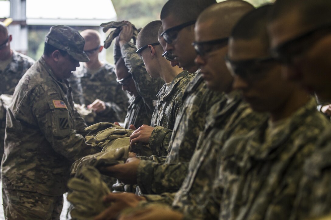 Soldiers in Basic Combat Training with E Company, 2nd Bn., 39th Inf. Reg., have their gloves and rappel seats inspected before attempting to rappel down the 40-foot wall at Victory Tower on Fort Jackson, S.C., Oct. 28, 2015. (U.S. Army photo by Sgt. 1st Class Brian Hamilton)