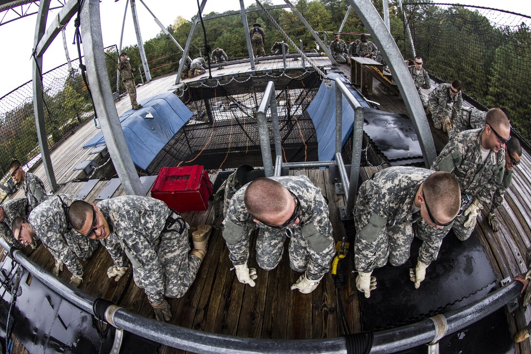 Soldiers in Basic Combat Training with E Company, 2nd Battalion, 39th Infantry Regiment, line up at the top of Victory Tower on Fort Jackson, S.C., Oct. 28, 2015. The Soldiers are preparing to rappel down a 40-foot wall, which is a requirement to graduate. (U.S. Army photo by Sgt. 1st Class Brian Hamilton)