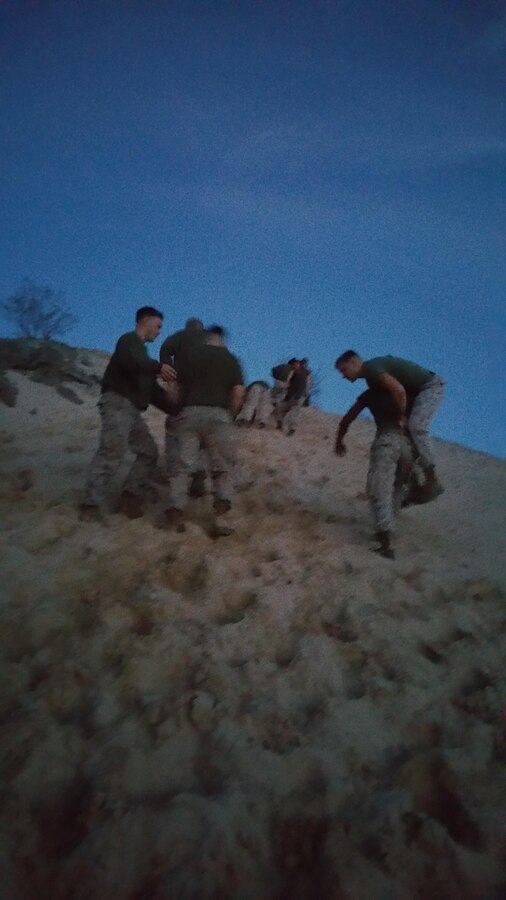 The Marines of MCCES Supply are conducting CFT Training in this picture by conducting maneuver under fire drills in teams while climbing Sugar Cookie.