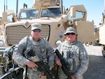Army Master Sgt. Micah Mason, an assistant operations noncommissioned officer, poses with his son, Army Pfc. Micah Mason, a gunner, prior to departing on a convoy escort mission in northern Iraq, Sept. 15, 2011. Both Soldiers are Kentucky National Guard members assigned to the 1st Battalion, 149th Infantry Regiment, 77th Sustainment Brigade, 310th Expeditionary Sustainment Command.