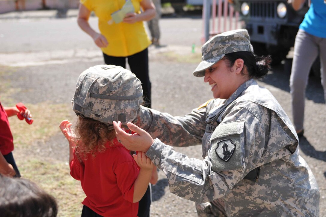 Soldiers of the 613th MP Company participate in Federal Day at El Tuque Head Start, Ponce, Puerto Rico, on Oct. 22.  Children ages 2-5 took turns trying on the Kevlar helmet and load bearing vest before lining up to climb up on the deuce and half truck.