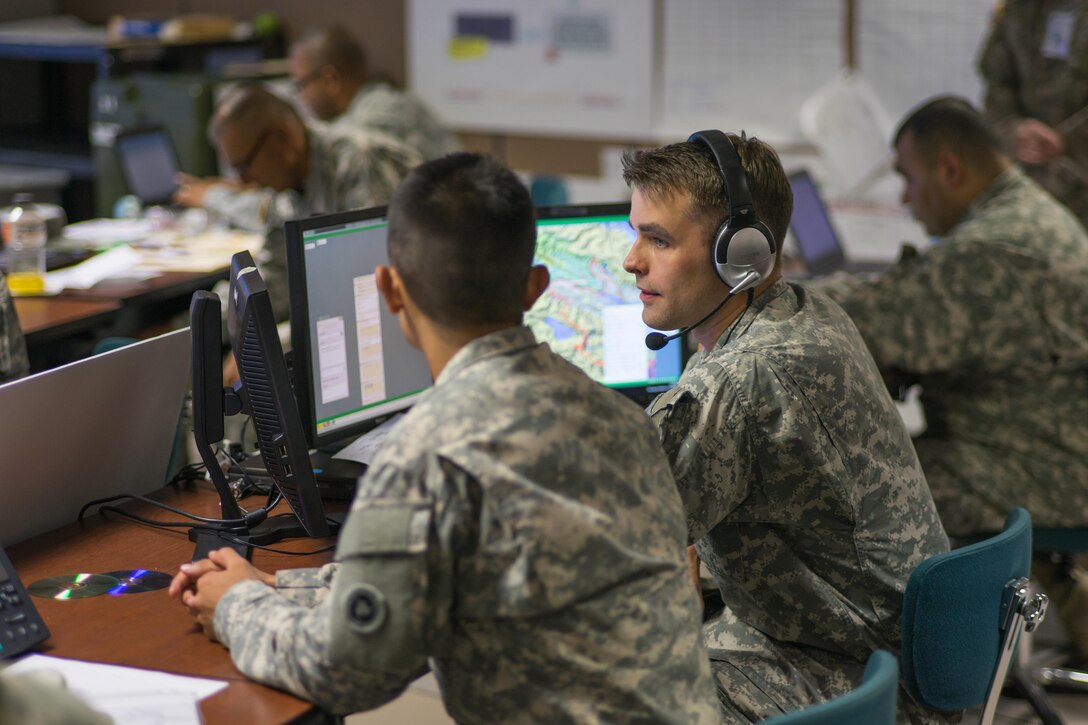 Sgt. Jon Findley (right), 311th Sustainment Command (Expeditionary) Intelligence Noncommissioned Officer, explains how to brief the enemy situation using the Command Post of the Future computer system with Pfc. Arturo Gonzalez (left) during the 311th Sustainment Command (Expeditionary) Command Post Exercise – Functional at Camp Parks, Calif., Sept. 19. The CPX-F uses a closed computer network, to simulate the operation of a command post within a simulated theater of operation, complete with inputs and feedback from notional higher, lower, adjacent and adversary units.