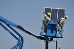 New York Air National Guard  Staff Sgt. Edwin Laporte and Hector Gomez, both members of the 106th Civil Engineering Squadron of the  106th Rescue Wing, install a solar panel at F.S. Gabreski Air National Guard Base in Westhampton Beach, New York on Sept. 8, 2015. The solar panels are part of a larger plan to reduce energy usage and save money by investing in renewable energy sources on base. 