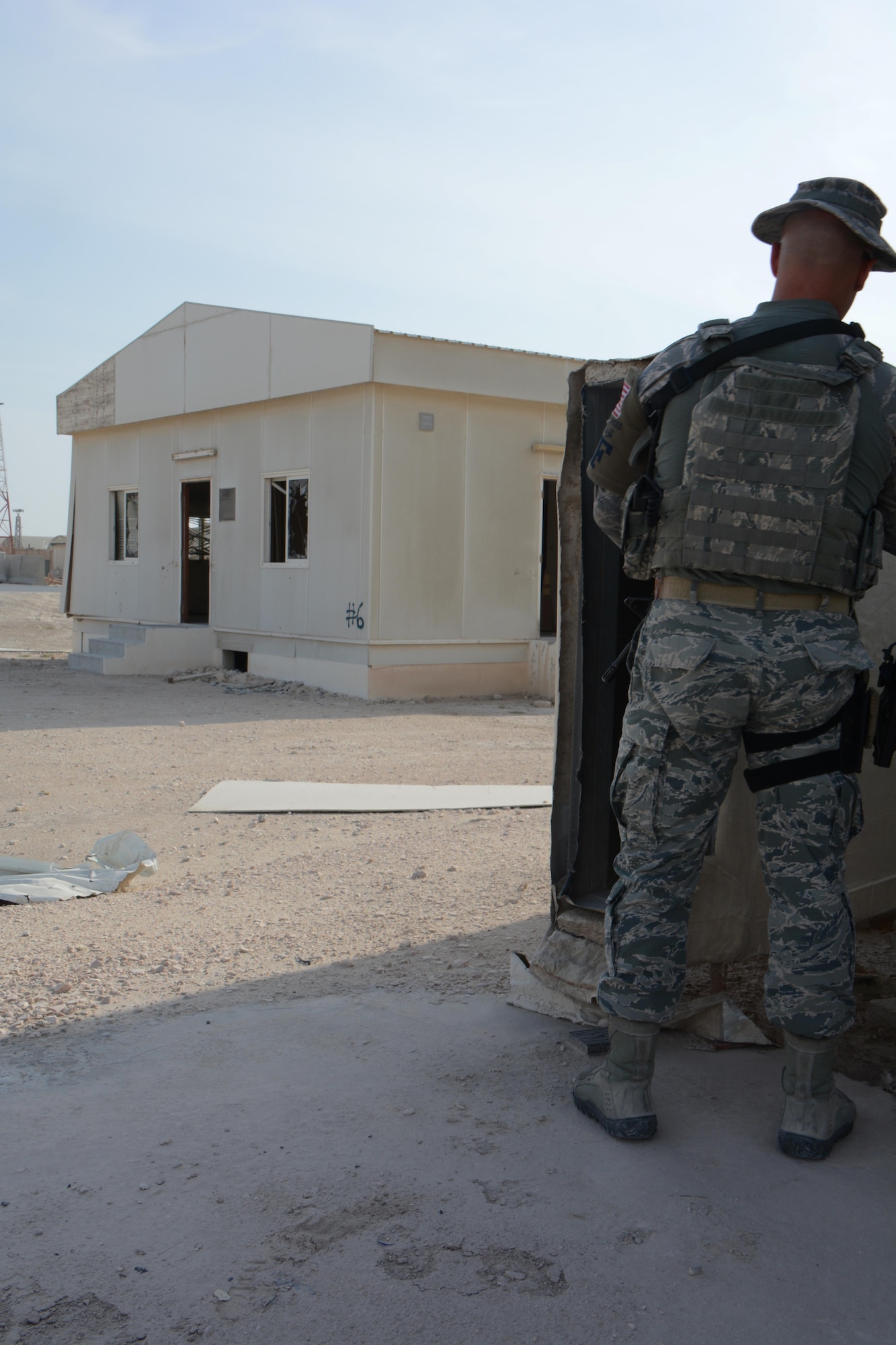 Tech. Sgt. Derek Pollock, 379th Expeditionary Security Forces Squadron, keeps a watchful eye on a building believed to house a suspect during an interagency training exercise at Al Udeid Air Base, Qatar Oct. 27. The exercise featured professionals from three 379th Air Expeditionary Wing units including explosive ordnance technicians, security forces patrolmen and firefighters. (U.S. Air Force photo by Tech. Sgt. James Hodgman)
