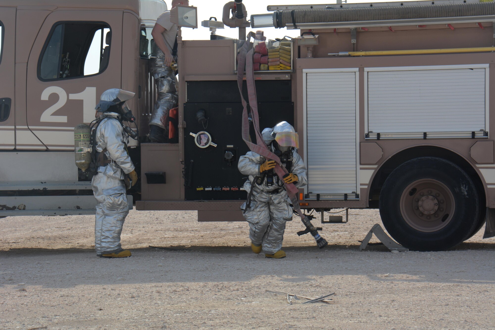 379th Expeditionary Civil Engineer Squadron firefighters arrive at the scene of a building fire during an interagency training exercise at Al Udeid Air Base, Qatar Oct. 27. The exercise featured professionals from three 379th Air Expeditionary Wing units including explosive ordnance technicians and security forces patrolmen and provided first responders with an opportunity to work together and learn from one another. (U.S. Air Force photo by Tech. Sgt. James Hodgman) 