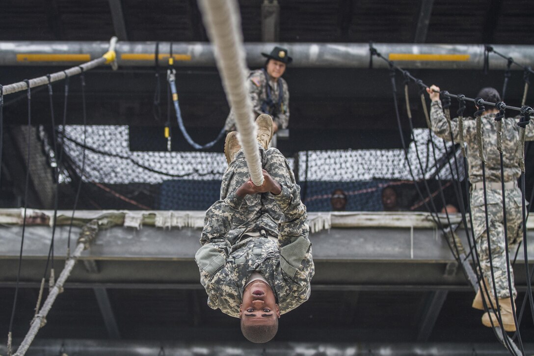 After losing his balance on a rope bridge obstacle, a soldier attempts to shimmy to the other side while his drill sergeant watches on Fort Jackson, S.C., Oct. 28, 2015. The soldier is assigned to Company E, 2nd Battalion, 39th Infantry Regiment. U.S. Army photo by Sgt. 1st Class Brian Hamilton