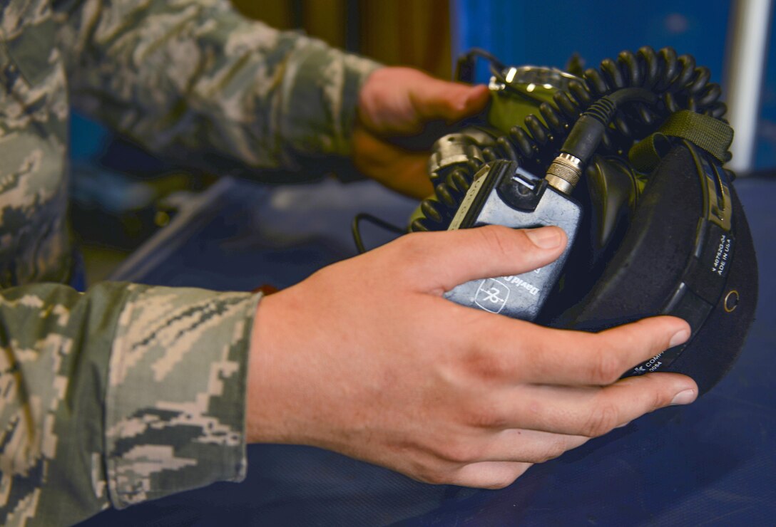 A support Airman inspects a pair of earphones before checking them out to crew chiefs at Eglin Air Force Base, Fla., Oct. 28, 2015.  Crew chiefs use these headphones to communicate with pilots before launch. (U.S. Air Force Photo/Senior Airman Andrea Posey)