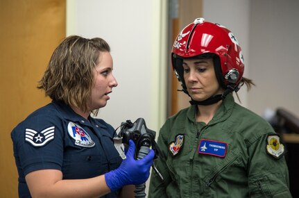 Staff Sgt. Madeline Conley, USAF Thunderbirds aircrew flight equipment specialist, at right, shows NBA Spurs Assistant Coach Becky Hammon air crew flight equipment and goes over in flight procedures with the coach before her media flight with the Thunderbirds at Joint Base San Antonio-Randolph Oct. 29.  The Thunderbirds are headlining the JBSA Air Show and Open House and will perform Oct. 31 and Nov. 1. (U.S. Air Force photo by Johnny Saldivar/Released)