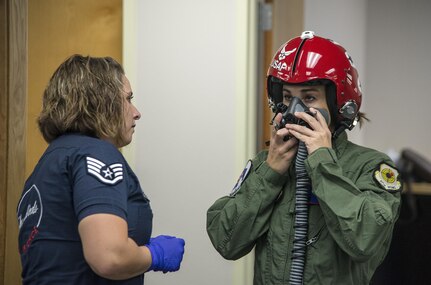 Staff Sgt. Madeline Conley, USAF Thunderbirds aircrew flight equipment specialist, at right, shows NBA Spurs Assistant Coach Becky Hammon air crew flight equipment and goes over in flight procedures with the coach before her media flight with the Thunderbirds at Joint Base San Antonio-Randolph Oct. 29.  The Thunderbirds are headlining the JBSA Air Show and Open House and will perform Oct. 31 and Nov. 1. (U.S. Air Force photo by Johnny Saldivar/Released)
