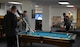 Airmen play a game of pool while others play ping pong Oct. 28, 2015 in the Higher Grounds Airmen Ministry Center, Bldg. 248, on F.E. Warren Air Force Base, Wyo. The center aims to create a local community for Airmen to go to and relax each night during the week. (U.S. Air Force photo by Senior Airman Brandon Valle)