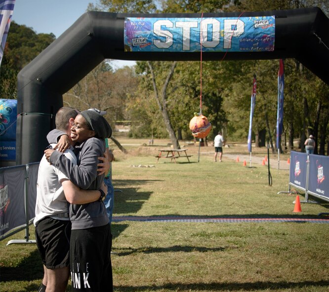 Tech. Sgt. Denarius Brittain (right) and her husband, Master Sgt. Torry Brittain, celebrate together at the finish line of the Pumpkin Holler Hunnerd, an ultramarathon at Tahlequah, Oklahoma, Oct. 18. The pair broke personal running records this weekend with Denarius finishing her first 50K and Torry completing an arduous 100-mile, 29-hour endurance test. (U.S. Air Force photo/ David Poe)