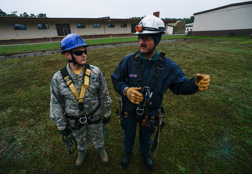 Airman 1st Class Patrick Dean, 1st Communications Maintenance Squadron cable and antenna systems technician, and Kurt Braunle, Specialized Technical Aided Rescue Training president, speak about safety procedures Oct. 9, 2015, at Ramstein Air Base, Germany. Cable and antenna maintenance technicians trained on multiple tower and ground emergency scenarios. (U.S. Air Force photo/Senior Airman Nicole Sikorski)
