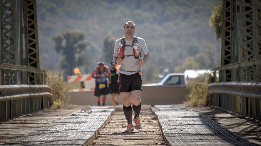 Master Sgt. Torry Brittain crosses the Illinois River in the final stretches of a 100-mile ultramarathon at Tahlequah, Oklahoma, Oct. 18. Running has taught me that I'm capable of more, he said in an Oct. 15 story at www.vance.af.mil.  Life would be very boring without challenges and I want to see where I stack up. (U.S. Air Force photo/ David Poe)