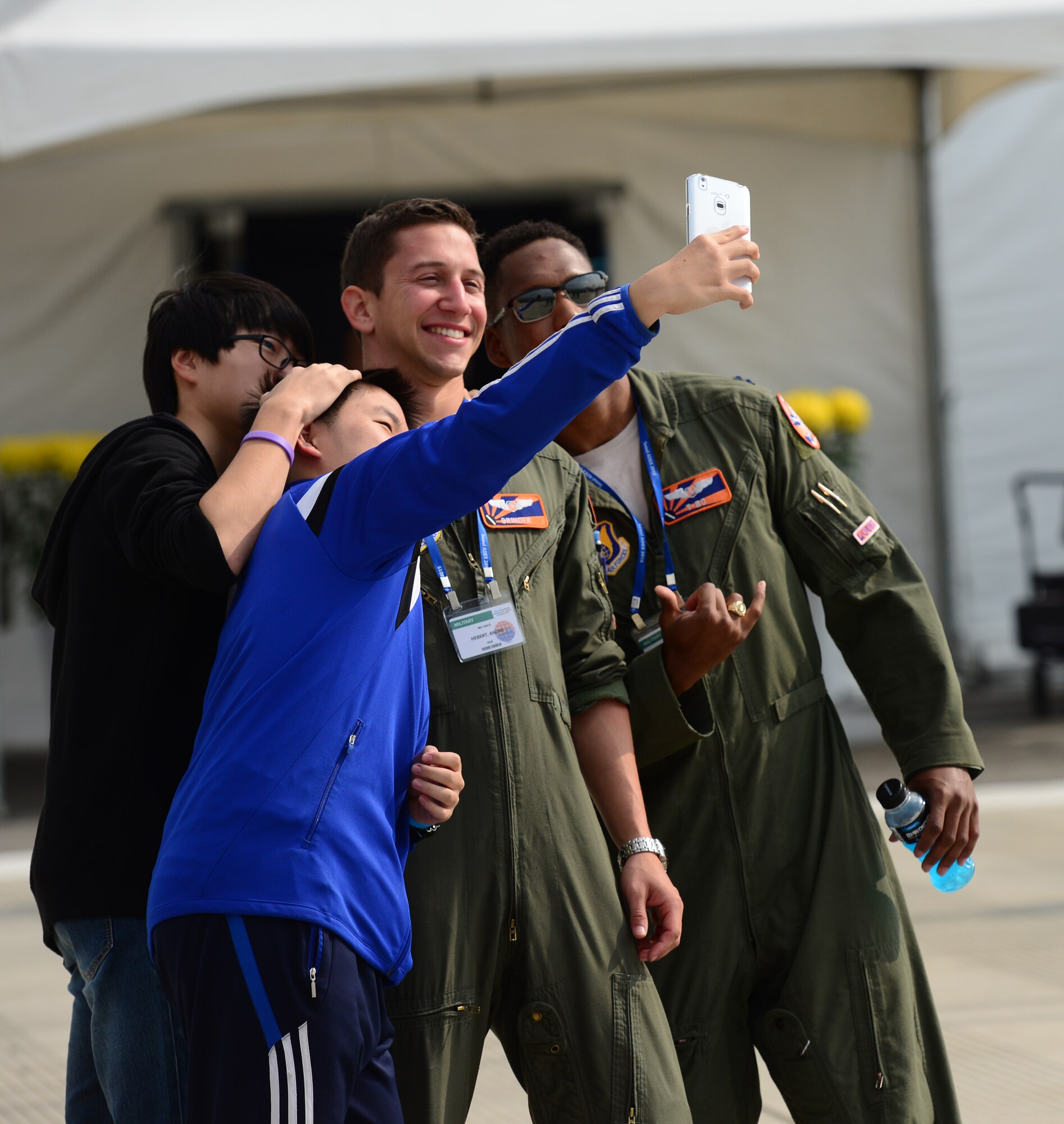 Capt. Craig Black and 1st Lt. Andre Hebert, 96st Airborne Air Control Squadron,  Kadena Air Base, Japan, pose for selfies with local Korean boys at the 2015 Seoul International Aerospace and Defense Exhibition held at Seoul Airport, Republic of Korea, Oct. 24, 2015. The Seoul ADEX gives American service members a chance to showcase their outstanding aircraft and equipment to the Korean public.
(U.S. Air Force photo/Staff Sgt. Amber Grimm)