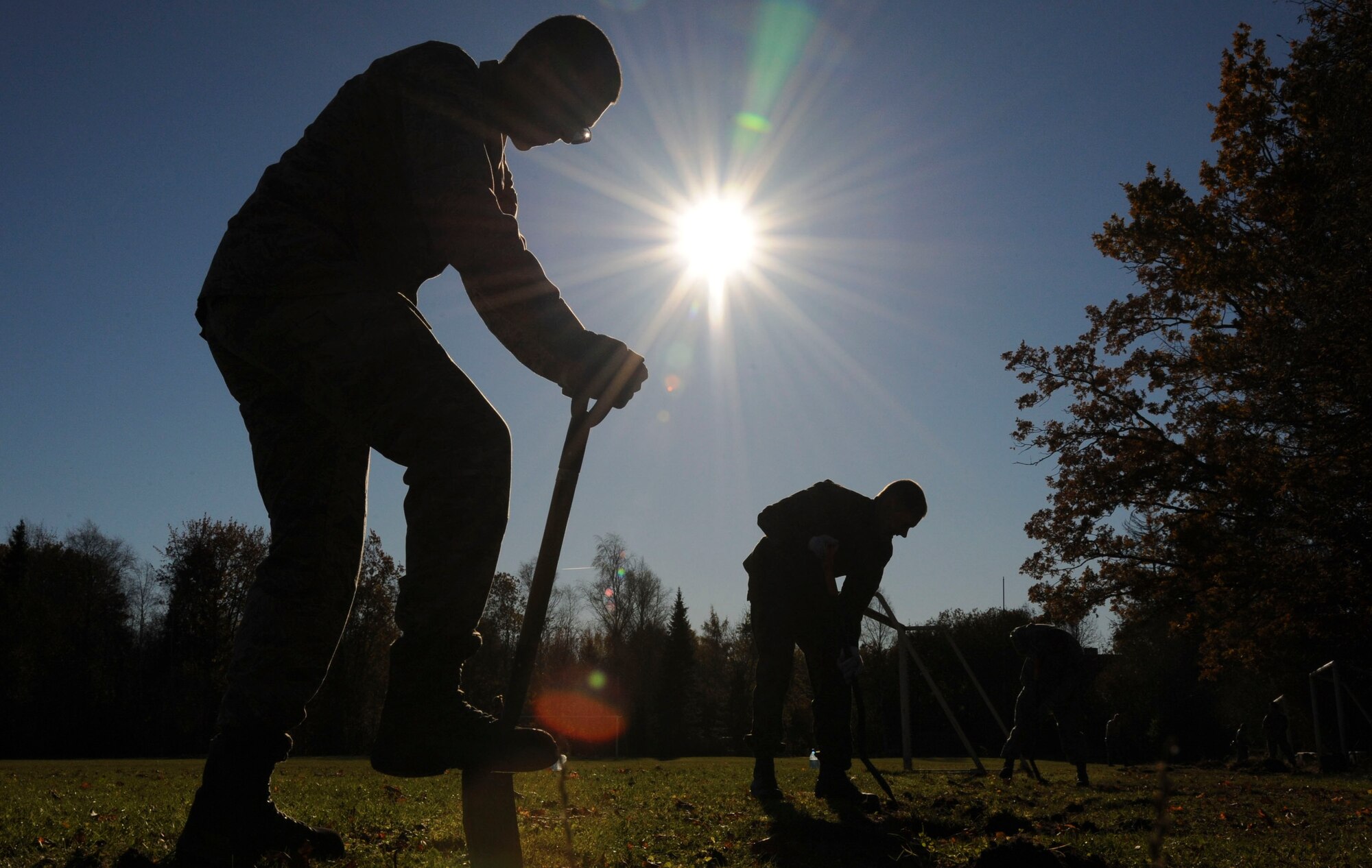 U.S. Air Force Airmen assigned to the 74th Expeditionary Fighter Squadron use shovels to edge the running path at Vasalemma School Stadium in Amari, Estonia, Oct. 24, 2015. The volunteers spent nearly eight hours helping the school clean up the recess area and build different obstacles for the students. (U.S. Air Force photo by Andrea Jenkins/Released)