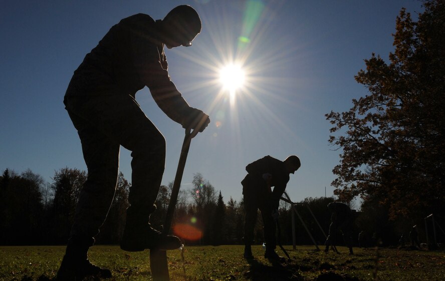 U.S. Air Force Airmen assigned to the 74th Expeditionary Fighter Squadron use shovels to edge the running path at Vasalemma School Stadium in Amari, Estonia, Oct. 24, 2015. The volunteers spent nearly eight hours helping the school clean up the recess area and build different obstacles for the students. (U.S. Air Force photo by Andrea Jenkins/Released)