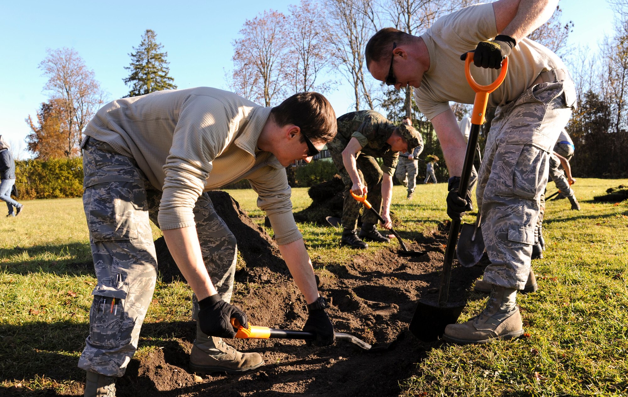 U.S. Air Force Airmen assigned to the 74th Expeditionary Fighter Squadron and German Air Force airmen dig a long-jump pit at Vasalemma School Stadium in Amari, Estonia, Oct. 24, 2015. About 100 volunteers helped the school clean up the recess area and build different obstacles for the students. (U.S. Air Force photo by Andrea Jenkins/Released)