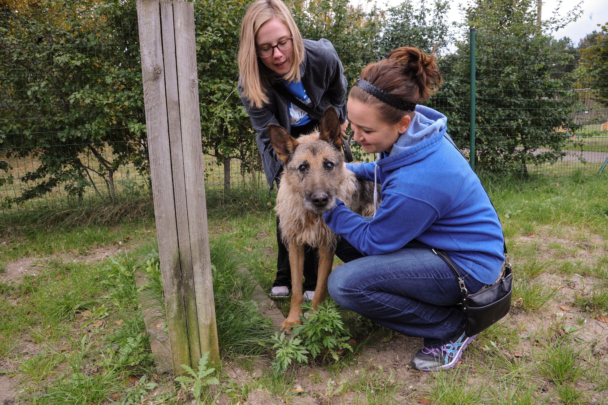 U.S. Air Force Airmen 1st Class Lisa Wippel and Corynn Collins, 74th Expeditionary Fighter Squadron munitions systems conventional crew members, spend time with an elderly-blind dog at a local animal shelter in Tallinn, Estonia, Oct. 10, 2015. Several 74th EFS Airmen volunteered their off-duty time to take dogs waiting for adoption on hour-long walks around the city. (U.S. Air Force photo by Andrea Jenkins/Released)