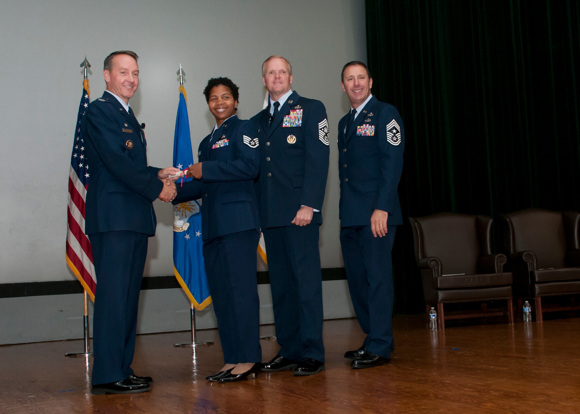Staff Sgt. Chanice Reid, 459th Force Support Squadron force management specialist, accepts her Community College of the Air Force diploma from Joint Base Andrews leadership at the Base Theater Oct. 27, 2015. Reid earned her CCAF in human resource management. (U.S. Air Force photo by Staff Sgt. Kat Justen)