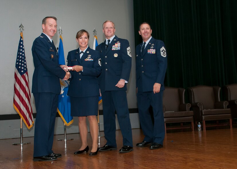 Master Sgt. Lori Hilgenberg, 459th Force Support Squadron unit training manager, accepts her Community College of the Air Force diploma from Joint Base Andrews leadership at the Base Theater Oct. 27, 2015. Hilgenberg earned her CCAF in education and training management. (U.S. Air Force photo by Staff Sgt. Kat Justen)