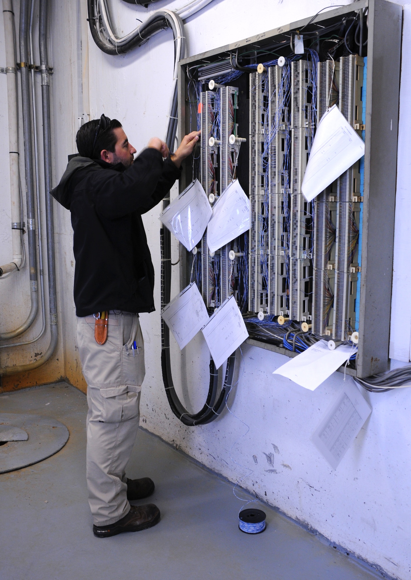 Joshua Sauer, electronics mechanic, 914th Communications Squadron installs jumper wires for secure telephone lines on Oct. 29, 2015 at the Niagara Falls Air Reserve Station, N.Y. Sauer was completing this task in preparation for members of the Defense Information Systems Agency to visit the base to conduct a Command Cyber Readiness Inspection which will assess the installation’s compliance with DOD Information Assurance policies as well as traditional and physical security standards. (U.S. Air Force photo by Staff Sgt. Matthew Burke/released)