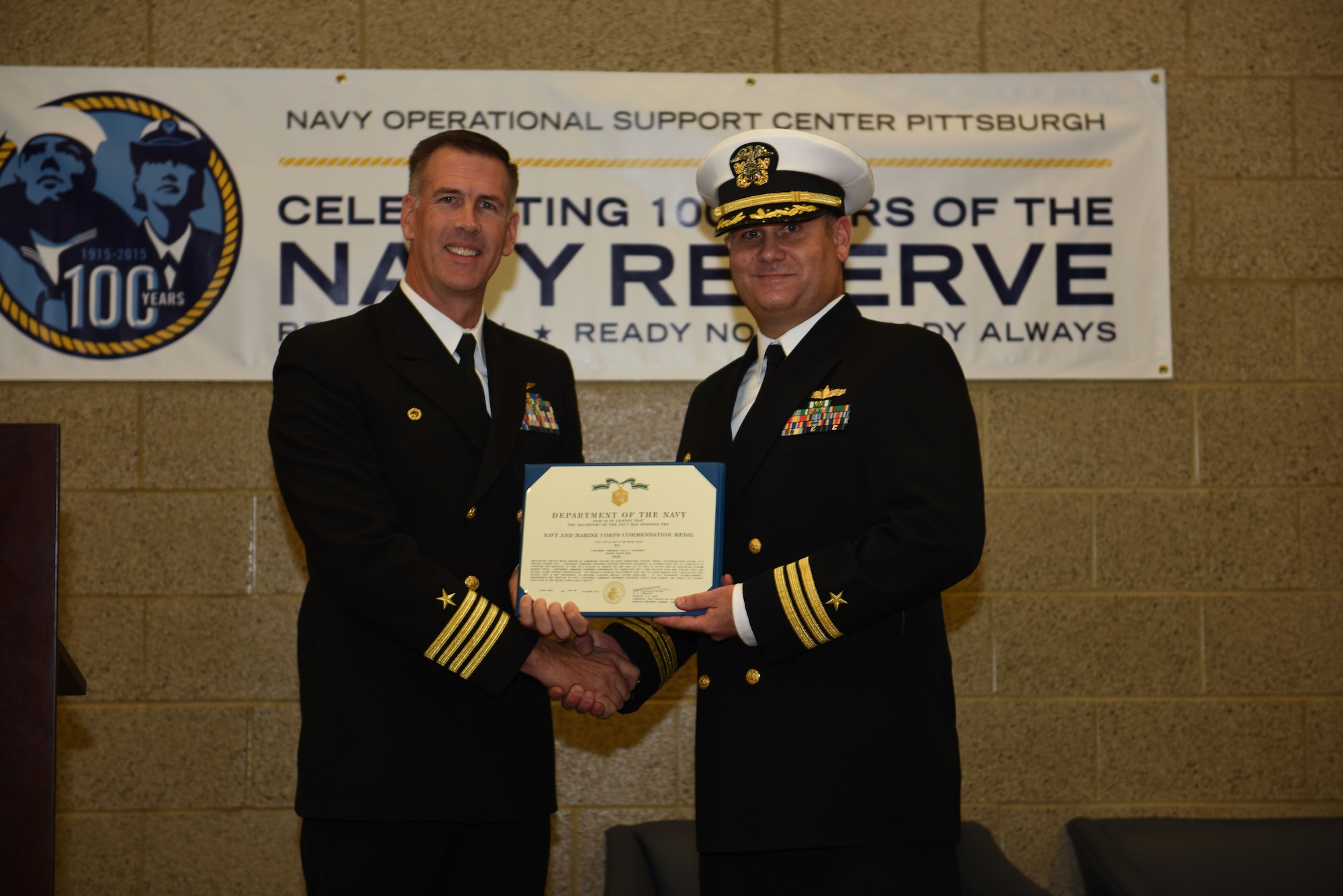 Navy Capt. Scott Laedlein awards Cmdr. Craig Frangente with the Navy and Marine Corps Commendation Medal during a change of command ceremony at the Pittsburgh International Airport Air Reserve Station, Oct. 3, 2015. Frangente relinquished command to Cmdr. Donald G. Haley. (U.S. Air Force photo by Senior Airman Marjorie A. Bowlden)