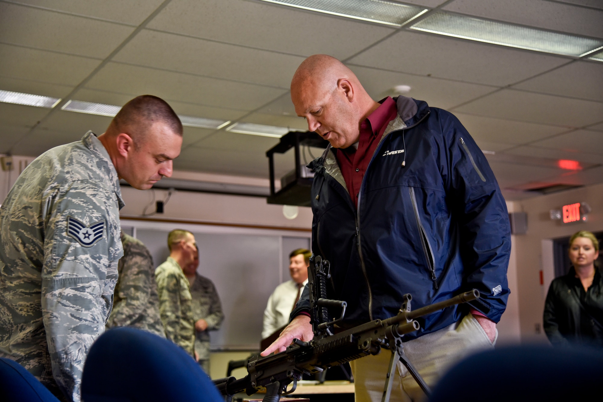 Staff Sgt. Caleb Myers, 92nd Security Forces Squadron combat arms instructor, answers questions asked about the M4 Carbine from Todd Kiesbuy, Regional Business Manager with Avistia Utilities, during an honorary commander’s tour Oct. 27, 2015, at Fairchild Air Force Base, Wash. The honorary commanders program brings together leaders from the military and civilian communities together in an informal program designed to continue to raise mutual understanding and establish bonds of friendship. (U.S. Air Force photo/Airman 1st Class Taylor Bourgeous)