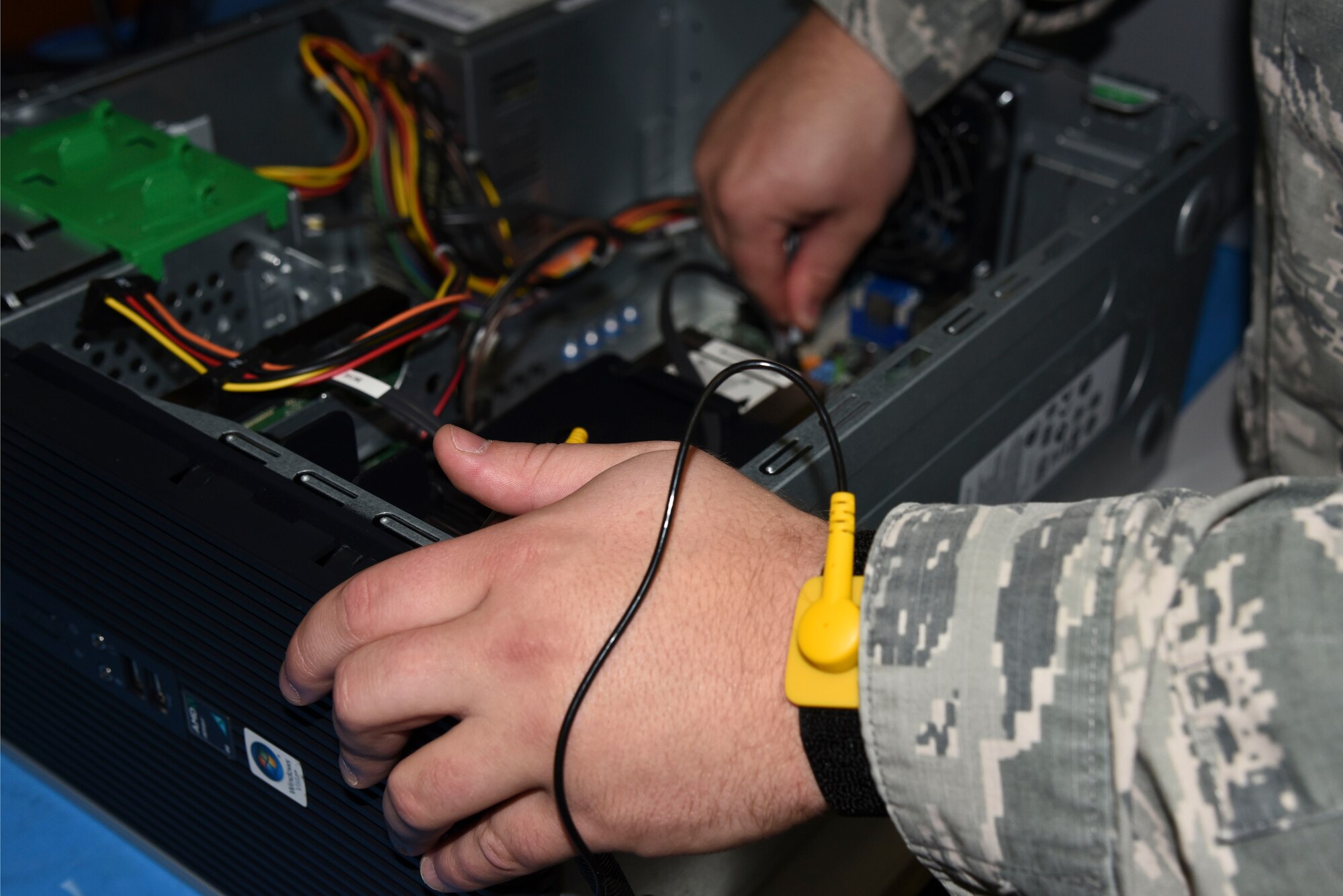 Senior Airman Bradly Stinger, 92nd Communications Squadron client systems team, wears a grounding strap while working on a damaged computer Oct. 29, 2015, at Fairchild Air Force Base, Wash. A grounding strap is used to prevent the buildup of static electricity on a person's body while working on a sensitive electronic equipment. (U.S. Air Force photo/Senior Airman Janelle Patiño)