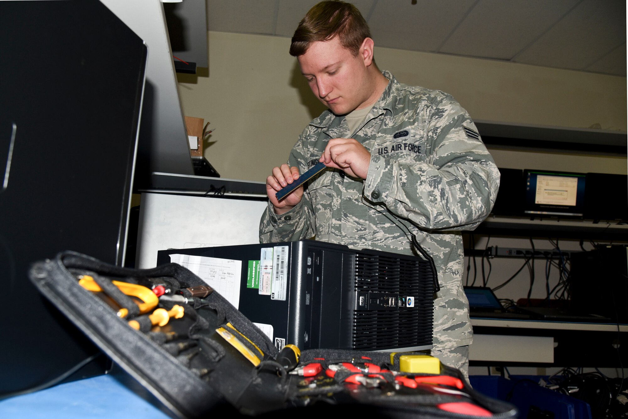 Senior Airman Bradly Stinger, 92nd Communications Squadron client systems technician, works on a damaged computer Oct. 29, 2015, at Fairchild Air Force Base, Wash. Airmen from the 92nd CS create a safe, secure and resilient cyber environment for personnel on base to be able to perform the mission successfully. Without a client systems team ensuring computers and printers are working properly, base personnel won't be able to accomplish their jobs, Stinger said. (U.S. Air Force photo/Senior Airman Janelle Patiño)