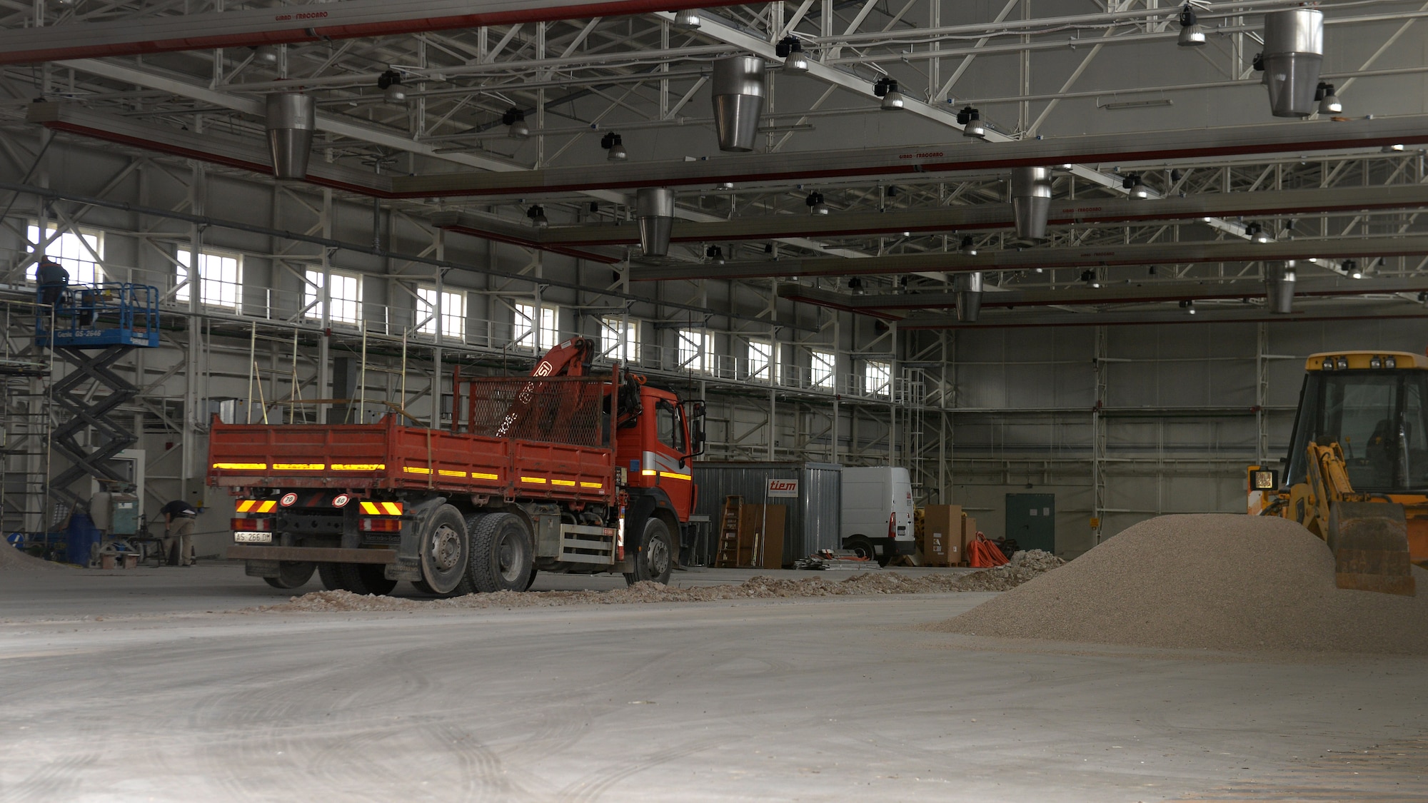 Construction crews use scaffolds and dump trucks to work inside Hangar 1, Oct. 27, 2015, at Aviano Air Base, Italy. Hangar 1 was approved for a complete renovation to replace outdated sections of the building. (U.S. Air Force photo by Airman 1st Class Cary Smith/Released)
