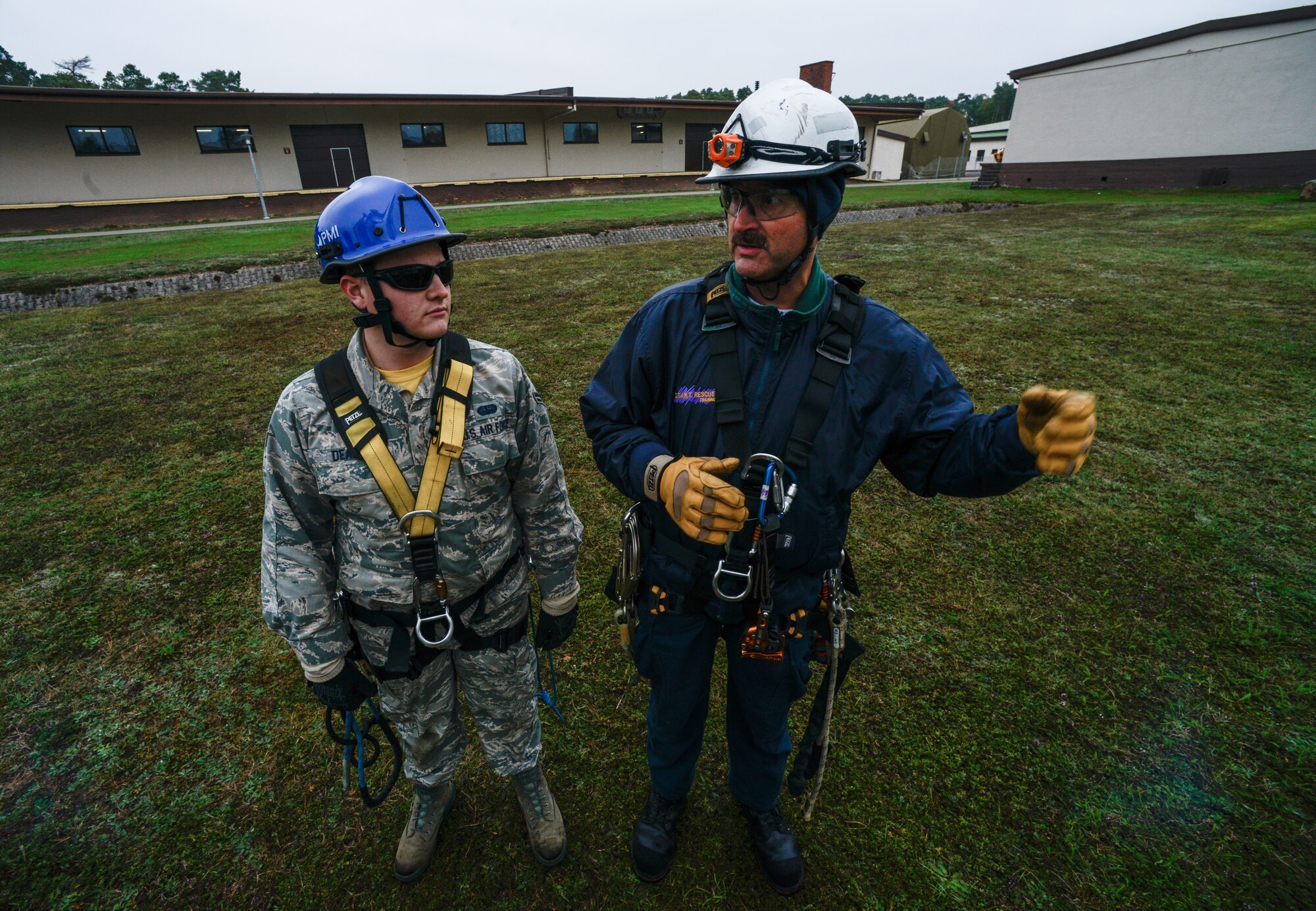 Airman 1st Class Patrick Dean, 1st Communications Maintenance Squadron cable and antenna systems technician, and Kurt Braunle, Specialized Technical Aided Rescue Training president, speak about safety procedures Oct. 9, 2015, at Ramstein Air Base, Germany. Cable and antenna maintenance technicians trained on multiple tower and ground emergency scenarios. (U.S. Air Force photo/Senior Airman Nicole Sikorski)
