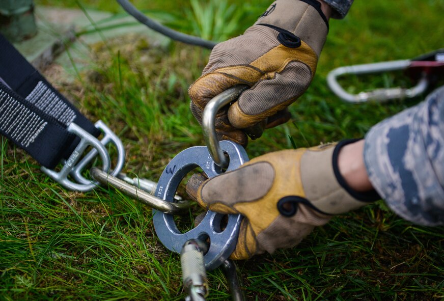 A cable and antenna systems technician from the 1st Communications Maintenance Squadron secures a rope before lowering a simulated victim from a telephone tower Oct. 9, 2015, at Ramstein Air Base, Germany. Cable and antenna maintenance technicians trained on multiple tower and ground emergency scenarios. (U.S. Air Force photo/Senior Airman Nicole Sikorski)