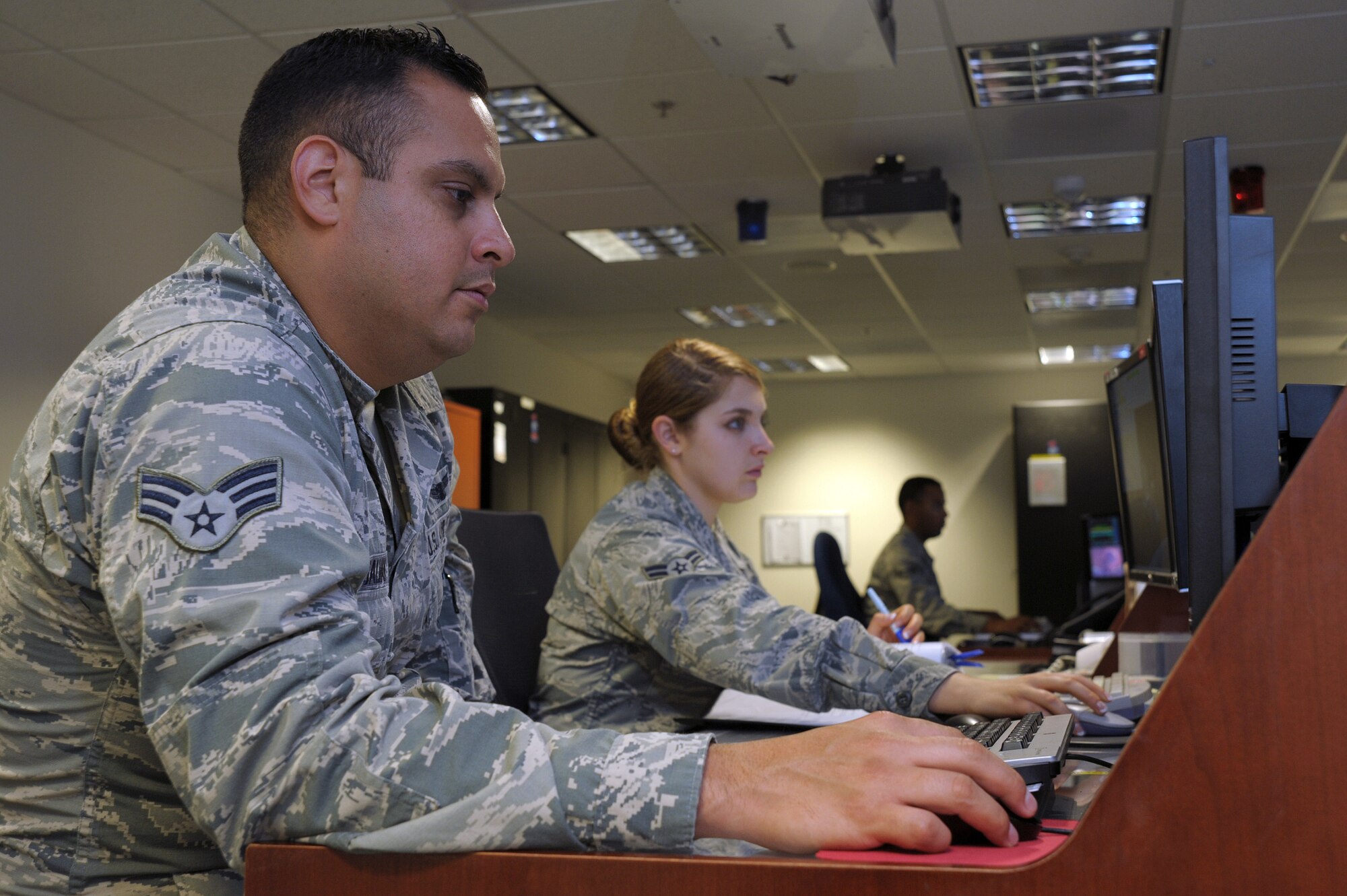 Senior Airman Benjamin Galvan and Airman 1st Class Presley Power, 148th Space Operations Squadron satellite systems operators, and Senior Airman Paul Davis, 148th SOPS terminal operator, man their respective stations for the Advanced Satellite Mission Control Subsystem, or ASMCS Oct. 29, 2015, Vandenberg Air Force Base, Calif. Galvan, Power and Davis represent the standard shift of a three person team of operators for the 148th SOPS, the first Air National Guard unit with a satellite command and control mission. (U.S. Air Force photo by Michael Peterson/Released)