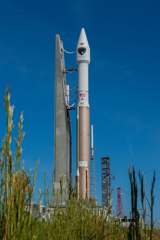 Appearing to rise out of the grass, an Atlas V 401 launch vehicle with GPS IIF-11 satellite aboard is rolled from the Vertical Integration Facility to Space Launch Complex-41 in anticipation of a Saturday afternoon launch from Cape Canaveral Air Force Station, Fla. The launch window opens Oct. 31 at 12:13 EDT (9:13 a.m. PDT). This is the second to last GPS IIF launch in a series of 12 spacecraft. The gray structure in the distance just to the left of the red construction crane is a new Crew Access Tower, currently nearing completion for future use by astronauts with the Boeing CST-100 manned spacecraft, slated for first flight in December 2017. (Photo courtesy United Launch Alliance).