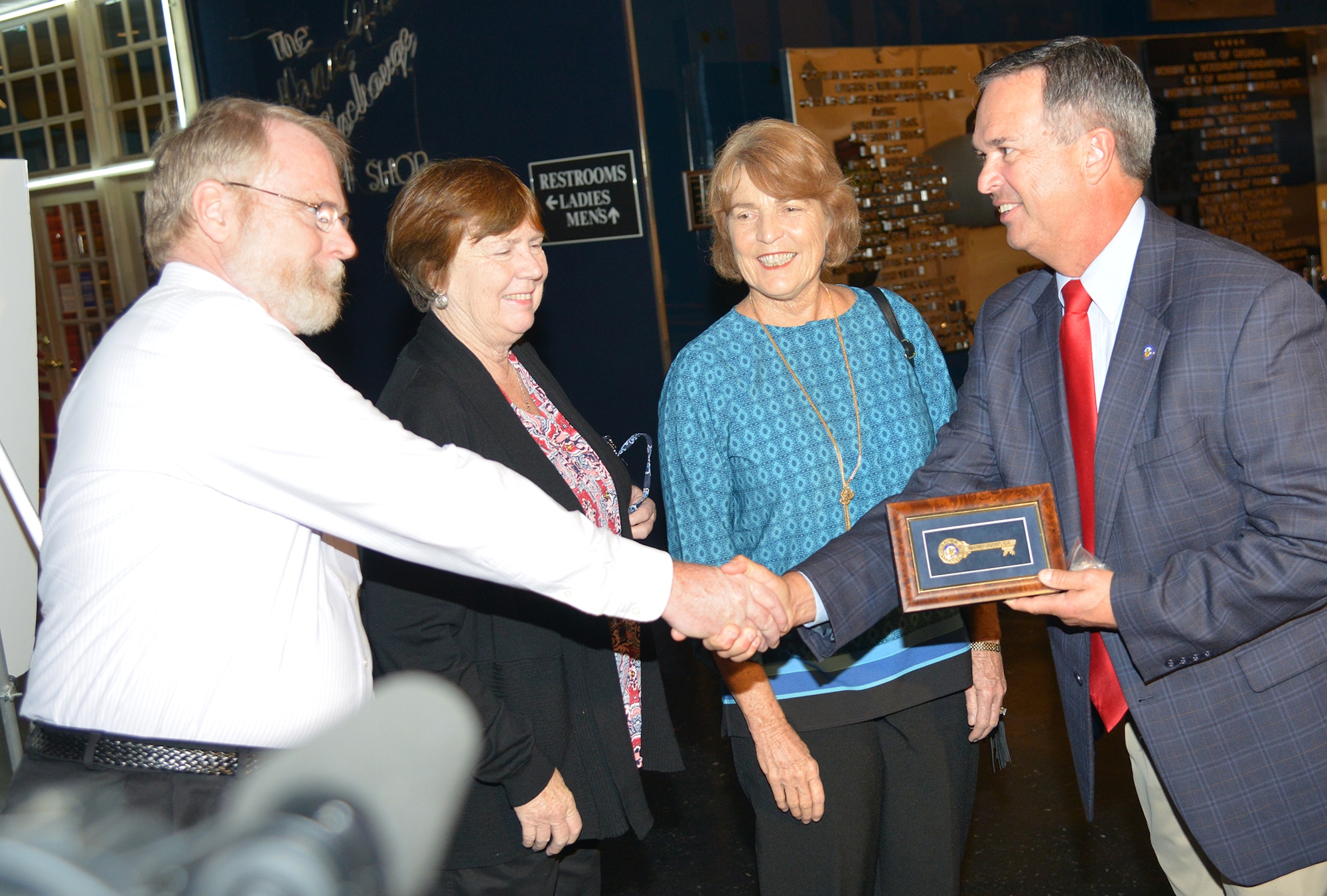 Warner Robins Mayor Randy Toms, right, shakes hands with Frank Guilfoyle as his sisters, Jane Guilfoyle Ward and Anne Guilfoyle Charlton, look on. The siblings are the grandchildren of Gen. Augustine Warner Robins, who both the town and the base are named after. Toms presented them with the key to the city. (U.S. Air Force photo by Ray Crayton)