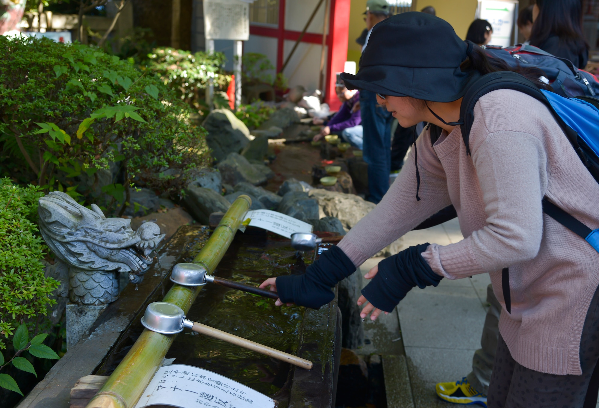 A Japanese woman places a chozu onto a bamboo stick at the Enoshima Island in Fujisawa City, Japan, Oct. 25, 2015. Chozu’s are used to purify a person’s hands and mouth before they pray. (U.S. Air Force photo by Senior Airman David Owsianka/Released)