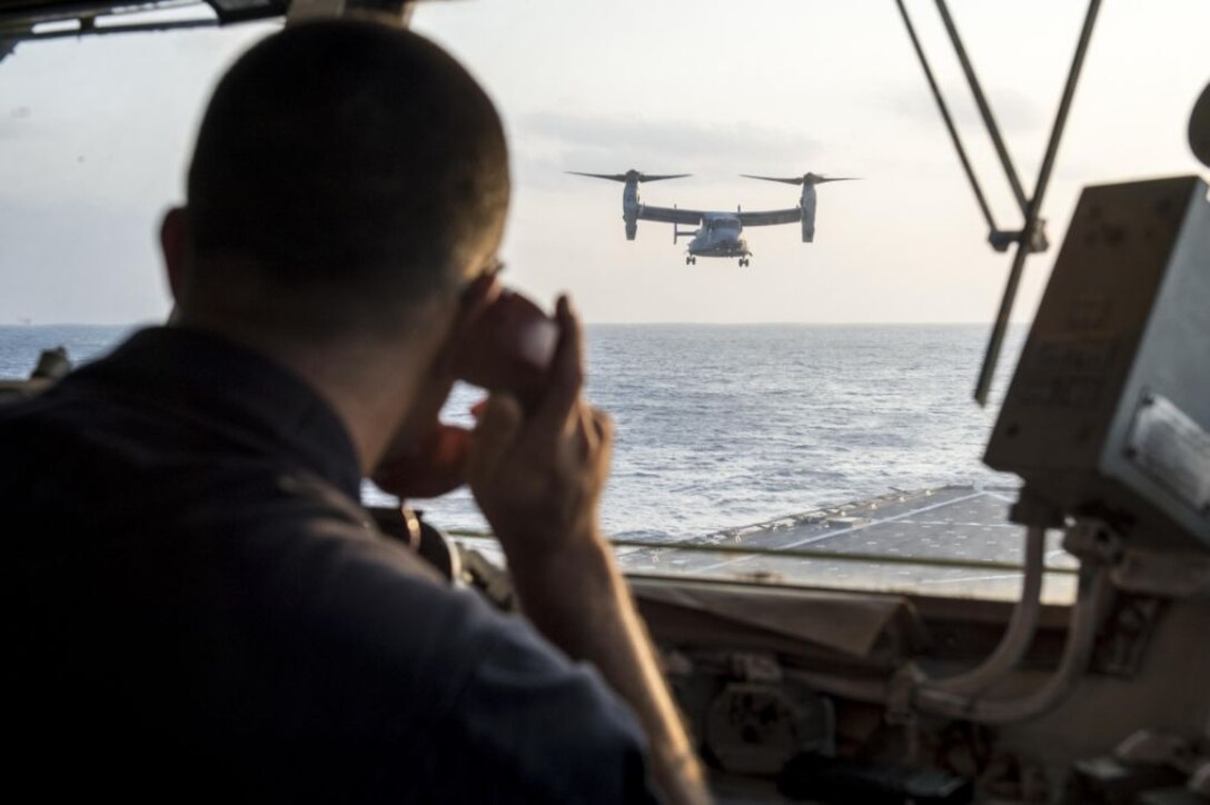 WATERS OFF OKINAWA, Japan – Senior Chief Culinary Specialist C. Wade Wilson, aircraft control officer aboard the amphibious dock landing ship USS Germantown (LSD 42), communicates with a MV-22 Osprey aircraft while landing on the flight deck aboard the ship during exercise Blue Chromite (BC) 16. BC 16 is a U.S. only exercise designed to increase amphibious proficiency between the Navy and Marine Corps. (U.S. Navy photo by Mass Communication Specialist 2nd Class Will Gaskill/Released) 