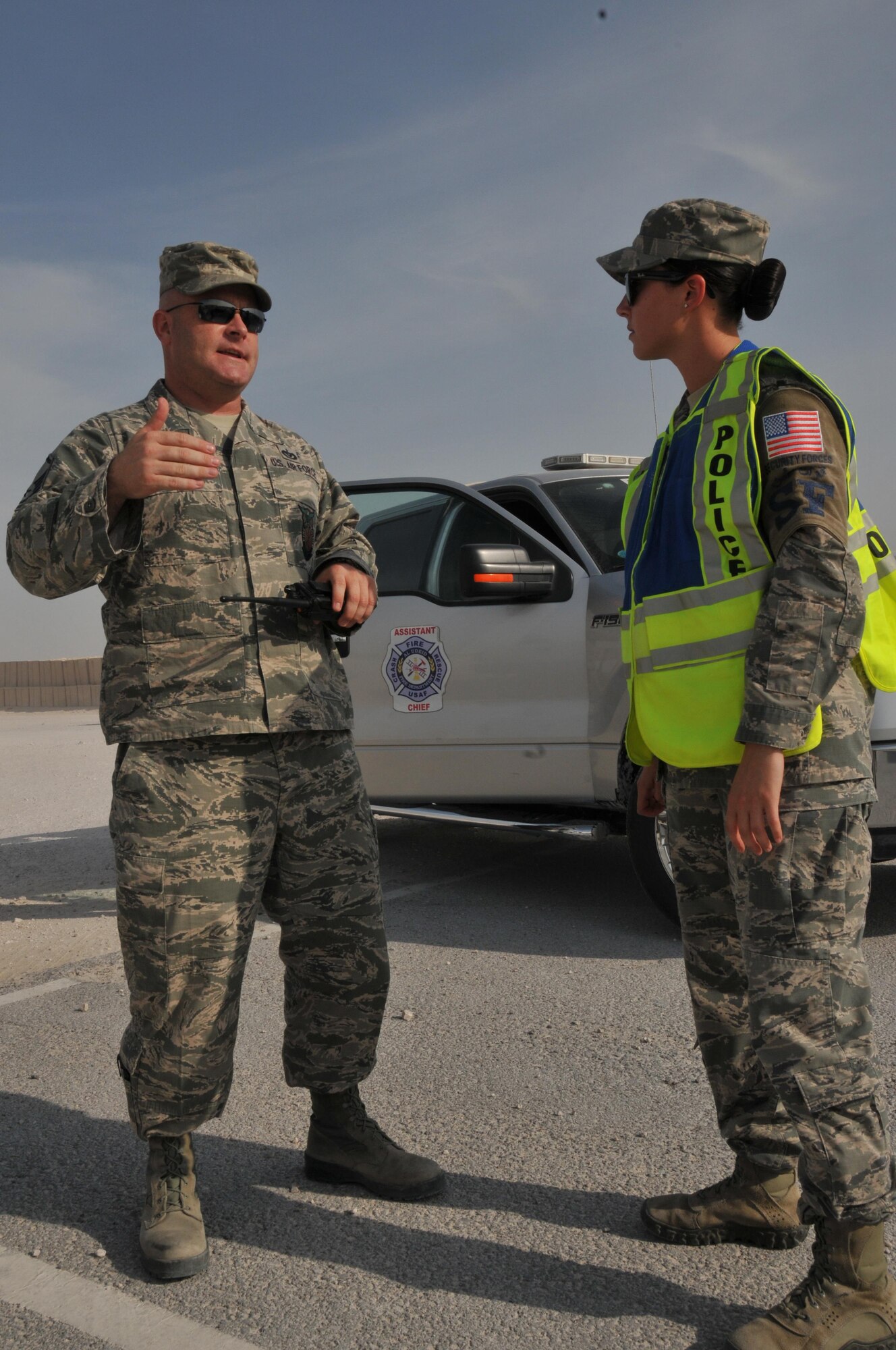 Master Sgt. Troy Romans, 379th Expeditionary Civil Engineer Squadron firefighter and incident commander for an interagency exercise Oct. 27 at Al Udeid Air Base, Qatar, meets with Staff Sgt. Kiirstyn Williams, 379th Expeditionary Security Forces Squadron, about a suspect during the exercise. The interagency exercise is an example of how first responders such as firefighters and security forces interact with one another. (U.S. Air Force photo by Tech. Sgt. Terrica Y. Jones/Released)