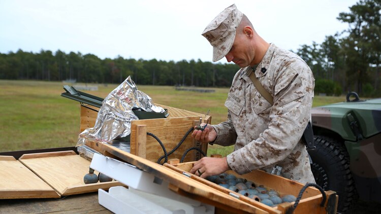 Master Sgt. Donald Johnson prepares M67 fragmentation grenades during a grenade and MK-19 Grenade Launcher range at Marine Corps Base Camp Lejeune, N.C., Oct. 28, 2015. More than 70 Marines with 2nd Low Altitude Air Defense Battalion took turns handling the MK19 and handheld grenades during the familiarization range. The range offered Marines the opportunity to build confidence and proficiency skills on some of the crew-served weapons they operate while providing security in a deployed environment. Johnson is the 24th Marine Expeditionary Unit Detachment staff noncommissioned officer in charge with the battalion.